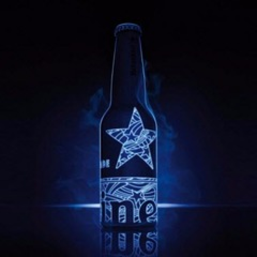 Eine Glasflasche Bier, die in neonblauem Licht leuchtet.