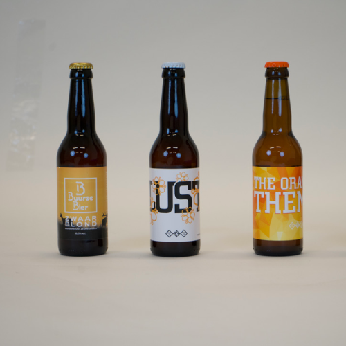 Drei Bierflaschen in einer Reihe, jede mit einem unterschiedlichen Etikett.
