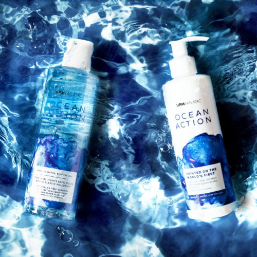 Zwei Hygiene-Flaschen mit einem Wasserhintergrund und blauer Reflexion.