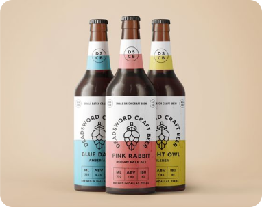 Drei Bierflaschen derselben Marke, jede mit einem Etikett in unterschiedlicher Farbe.