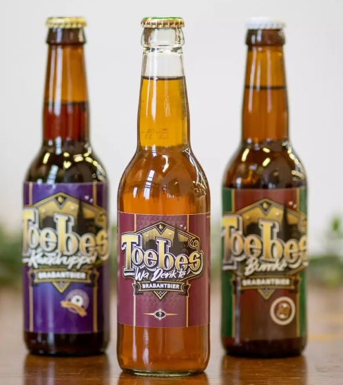 Drei Glasbierflaschen der gleichen Marke, jede mit einem anderen Etikettendesign.